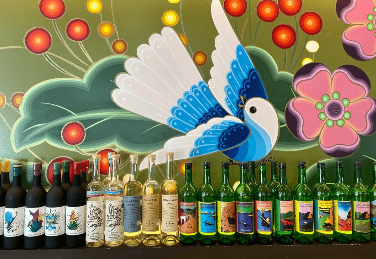 Folk-art mural and mezcal bottles inside Nopalito, San Francisco
